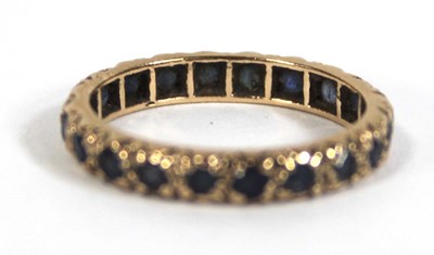 Lot 570 - A 9ct yellow gold eternity ring set sapphires,...