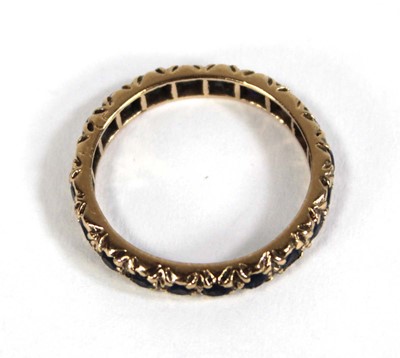 Lot 570 - A 9ct yellow gold eternity ring set sapphires,...