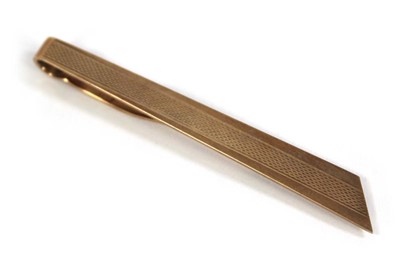 Lot 574 - A 9ct yellow gold engine turned tie clip,...