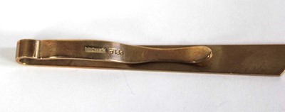 Lot 574 - A 9ct yellow gold engine turned tie clip,...