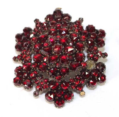 Lot 580 - A gold plated garnet brooch/pendant of...