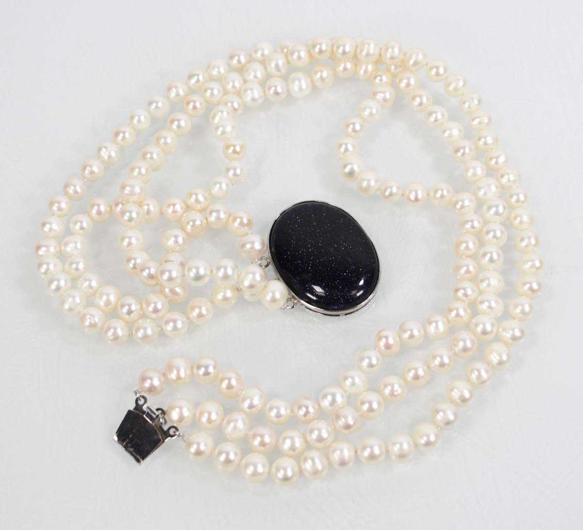 Lot 719 - A triple strand cultured pearl necklace with...