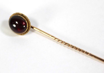 Lot 623 - A yellow metal stick pin set cabochon garnet...