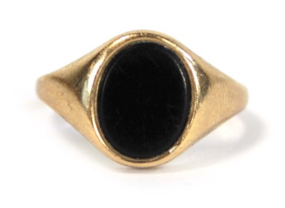 Lot 631 - A yellow metal pinky signet ring set black...