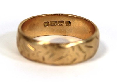 Lot 634 - An 18ct yellow gold engraved wedding band,...