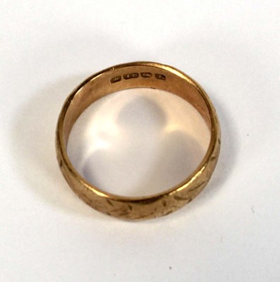 Lot 634 - An 18ct yellow gold engraved wedding band,...
