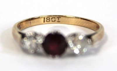 Lot 644 - An 18ct yellow gold ring set garnet and two...