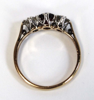 Lot 644 - An 18ct yellow gold ring set garnet and two...
