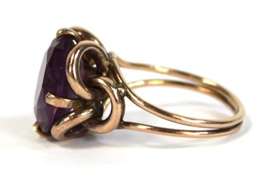 Lot 645 - A yellow metal ring set oval amethyst coloured...