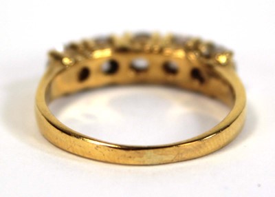 Lot 651 - A yellow metal ring set five white stones in...