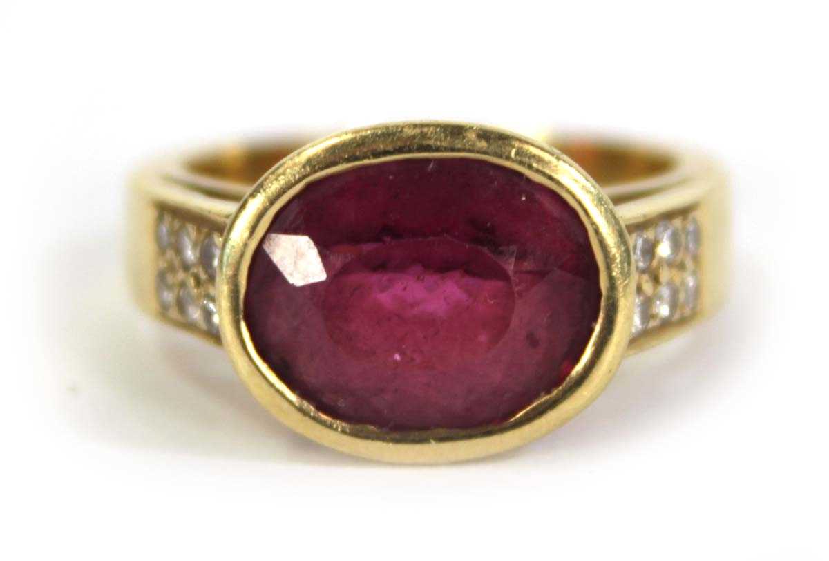 Lot 730 - A yellow metal ring set oval pink stone within...