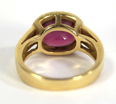 Lot 730 - A yellow metal ring set oval pink stone within...