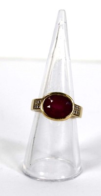 Lot 730 - A yellow metal ring set oval pink stone within...