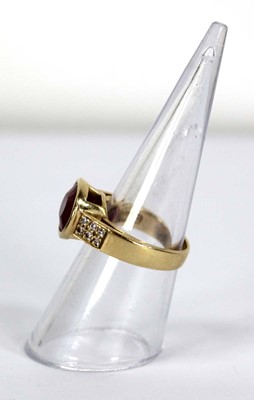 Lot 730 - A yellow metal ring set oval pink stone within...