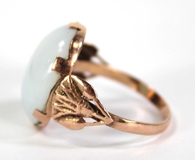 Lot 733 - An Egyptian rose gold ring set oval opaline...