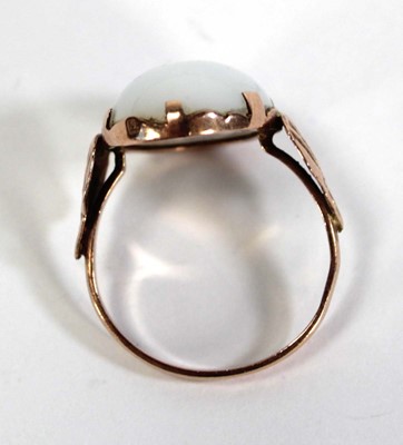 Lot 733 - An Egyptian rose gold ring set oval opaline...