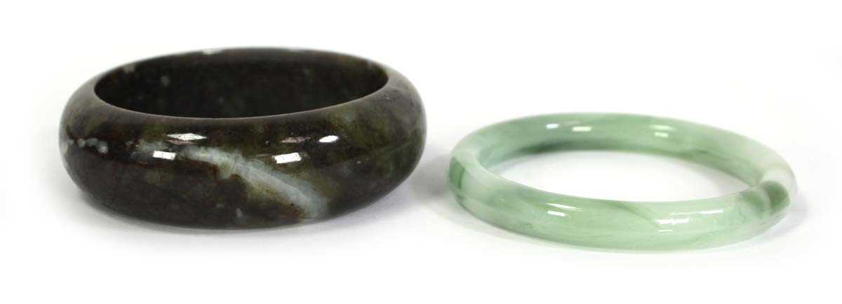 Lot 740 - Two jade-type bangles, internal d. 6.7 cm and...
