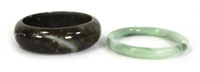 Lot 740 - Two jade-type bangles, internal d. 6.7 cm and...