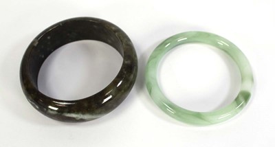 Lot 740 - Two jade-type bangles, internal d. 6.7 cm and...