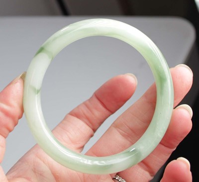 Lot 740 - Two jade-type bangles, internal d. 6.7 cm and...