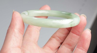 Lot 740 - Two jade-type bangles, internal d. 6.7 cm and...