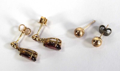 Lot 753 - A pair of 9ct yellow gold ear pendants set red...