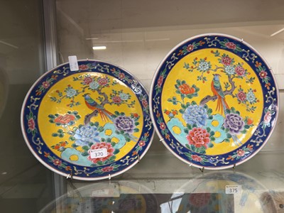 Lot 370 - A pair of oriental ceramic chargers with bird...