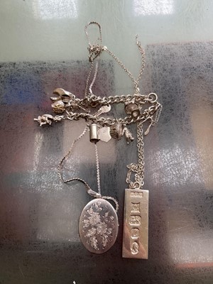 Lot 444 - A charm bracelet with locket, bar, and necklaces