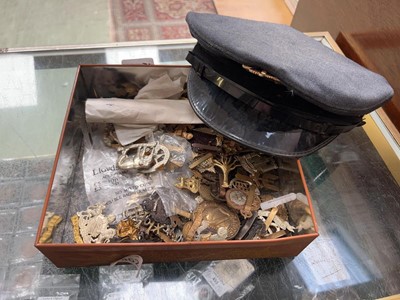 Lot 462 - A tin of various cap badges along with an RAF hat