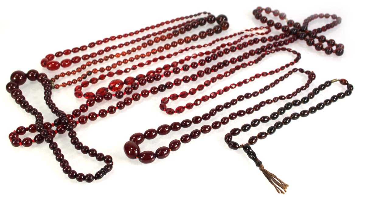 Lot 773 - Nine cherry amber-style and costume necklaces (9)