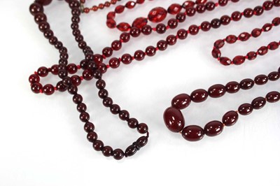 Lot 773 - Nine cherry amber-style and costume necklaces (9)