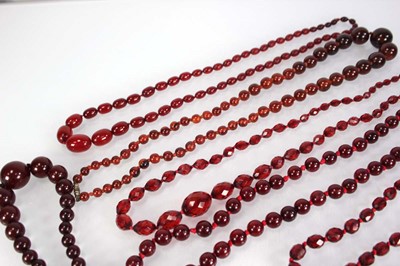Lot 773 - Nine cherry amber-style and costume necklaces (9)