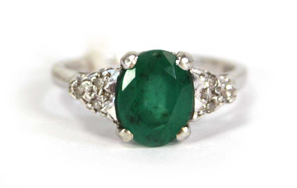 Lot 783 - A 9ct white gold ring set oval emerald and...