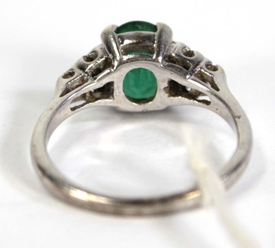 Lot 783 - A 9ct white gold ring set oval emerald and...