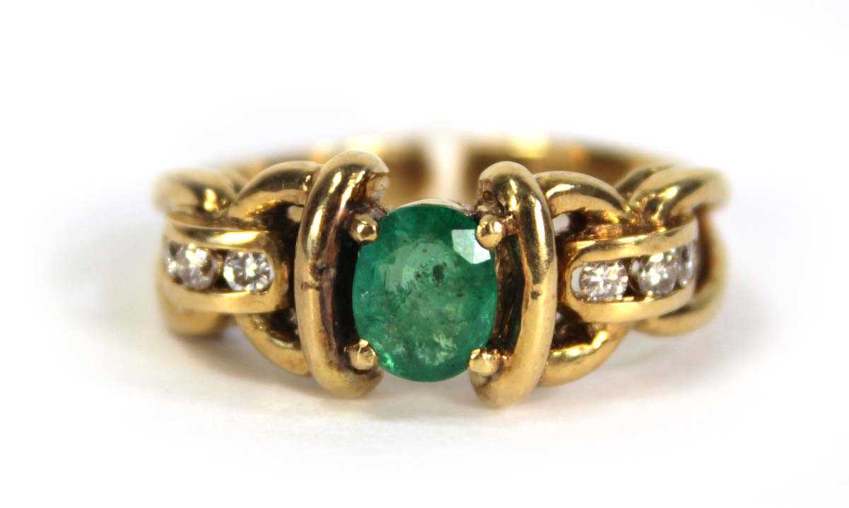 Lot 784 - An 18ct yellow gold ring set oval emerald and...