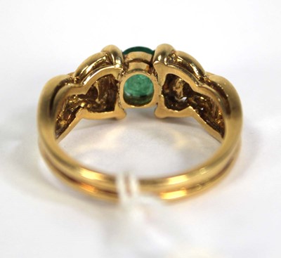 Lot 784 - An 18ct yellow gold ring set oval emerald and...
