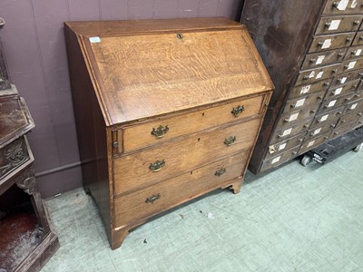 Lot 53 - An oak fall front bureau with three drawers on...