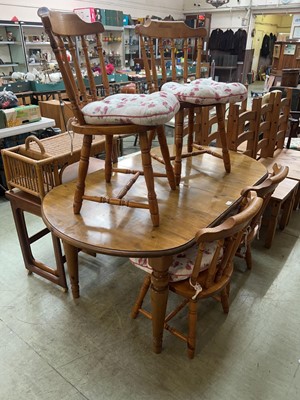 Lot 75 - An oval pine extending kitchen table and four...