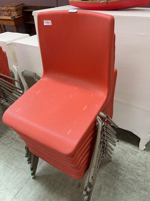 Lot 64 - A collection of 9 stacking PVC chairs in red