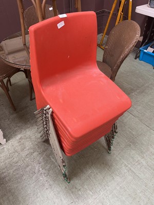 Lot 65 - A collection of 9 stacking PVC chairs in red