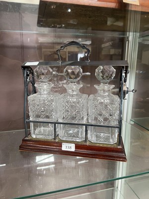 Lot 338 - A mahogany and plated Tantalus containing 3...