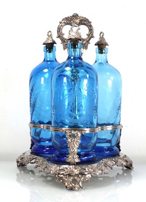 Lot 314 - A silver plated three bottle stand decorated...