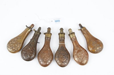 Lot 1045 - Six copper and brass powder flasks, inc. three...