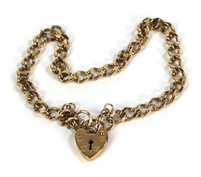 Lot 501 - A 9ct yellow gold curblink bracelet with heart...