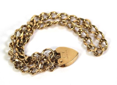Lot 501 - A 9ct yellow gold curblink bracelet with heart...
