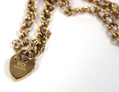 Lot 501 - A 9ct yellow gold curblink bracelet with heart...