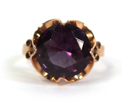 Lot 511 - A 14ct yellow gold ring set circular purple...