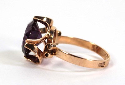 Lot 511 - A 14ct yellow gold ring set circular purple...