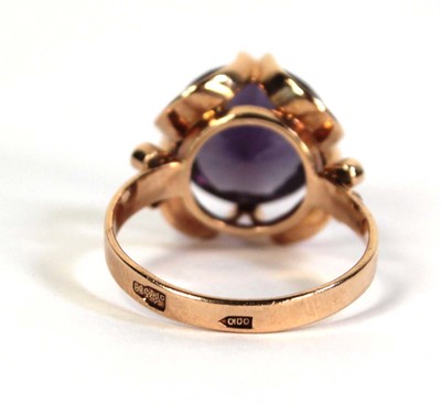 Lot 511 - A 14ct yellow gold ring set circular purple...