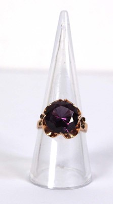Lot 511 - A 14ct yellow gold ring set circular purple...
